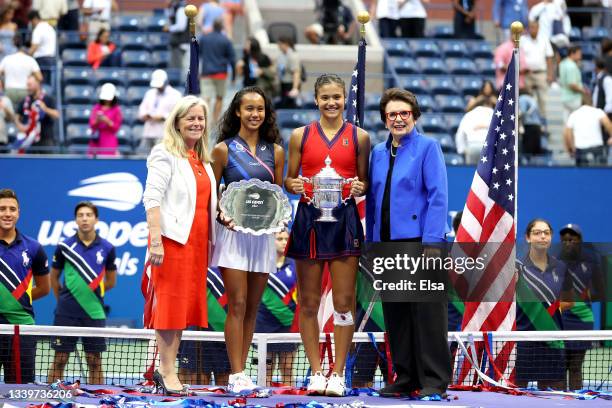 Leylah Annie Fernandez of Canada holds the runner-up trophy as Emma Raducanu of Great Britain celebrates with the championship trophy alongside...