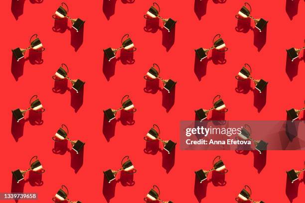 pattern made of metallic golden goblets on red background with shadows. flat lay style - trophy flat stockfoto's en -beelden