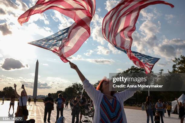 Woman waves American flags during a "Let Us Worship" prayer service on September 11, 2021 in Washington, DC. The nation is marking the 20th...
