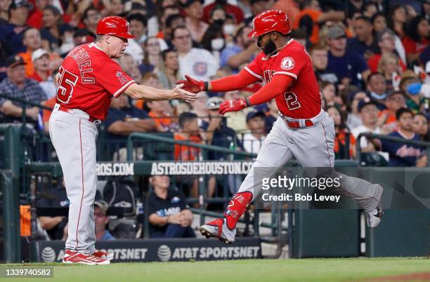 Luis Rengifo of the Los Angeles Angels receives congratulations from Brian Butterfield after hitting a two run home run in the third inning against...