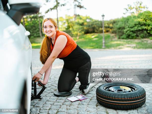 woman, leg amputee having car flat tire - prosthetic limb stock pictures, royalty-free photos & images