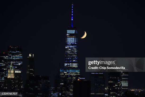 The moon is seen past One World Trade Center in Lower Manhattan on September 11, 2021 in New York City. The nation is marking the 20th anniversary of...