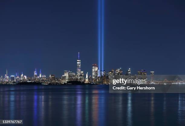 The annual Tribute in Light is illuminated behind the Statue of Liberty and next to One World Trade Center in New York City on the 20th anniversary...