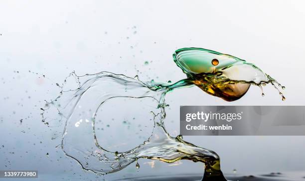 water splashing on water surface - olive oil splash stock pictures, royalty-free photos & images