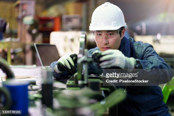 man using dial indicator for precision alignment during work preparation. - industrial machinery stock-fotos und bilder