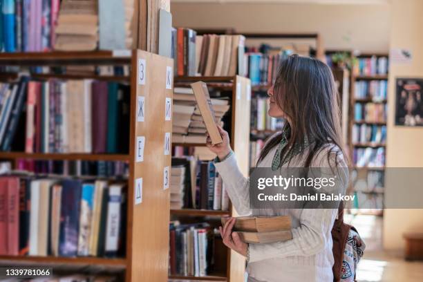 female student in the campus library. - linguistics 個照片及圖片檔