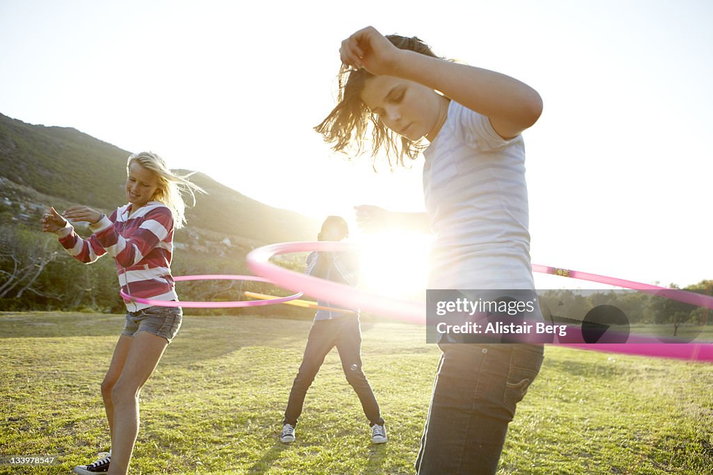 Teenage girls hula-hooping together