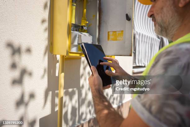 close up technician repairing gas furnace using digital tablet - electrical testing bildbanksfoton och bilder