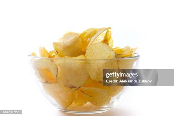 crispy fried fat potato chips in a glass bowl or plate, on a white wooden background or table. the concept of an unhealthy diet and lifestyle, the accumulation of excess weight. copy of the text space. - chip stock-fotos und bilder
