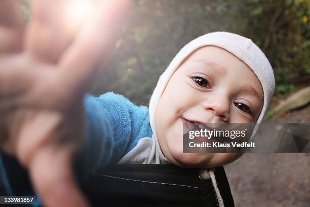 Baby boy smiling reaching for camera