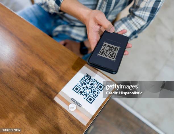 close-up on a man scanning a qr code at a restaurant - qr code food and drink stock pictures, royalty-free photos & images