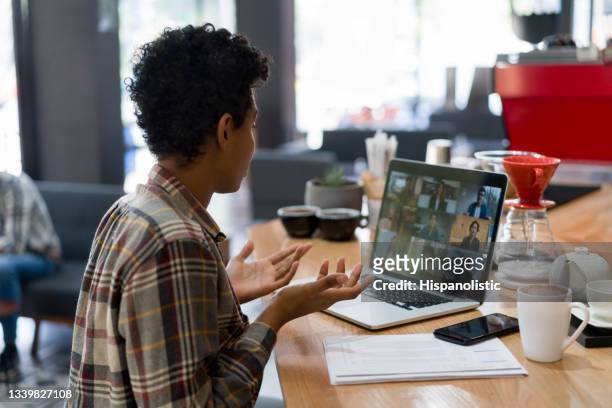 woman on a video conference at a coffee shop - medium group of people stock pictures, royalty-free photos & images