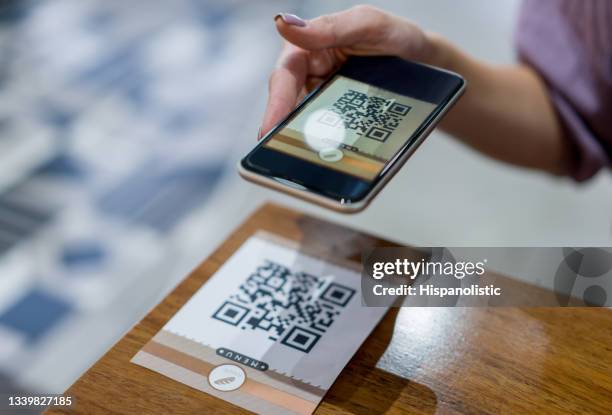 close-up on a woman scanning a qr code at a restaurant - qr code food and drink stock pictures, royalty-free photos & images