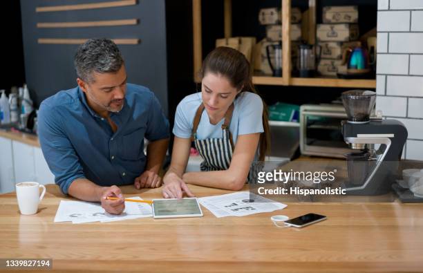 business owner doing to the books at a cafe with a waitress - opening event stock pictures, royalty-free photos & images