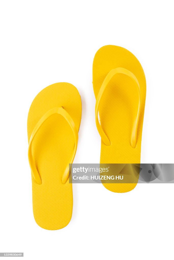 Pair of yellow beach flip-flops on white background summer concept