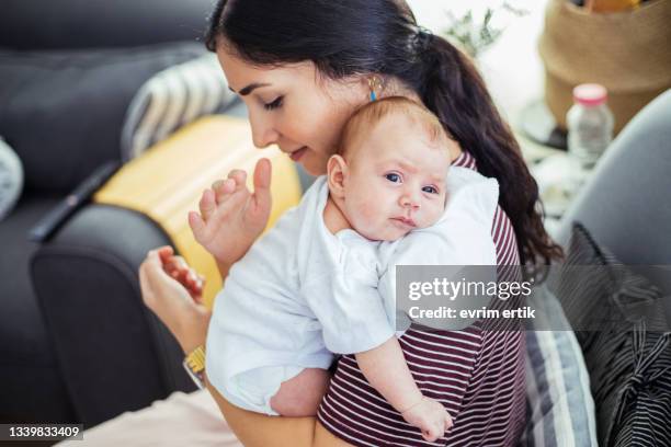 mutter hält das baby zum aufstoßen über die schulter - burping stock-fotos und bilder