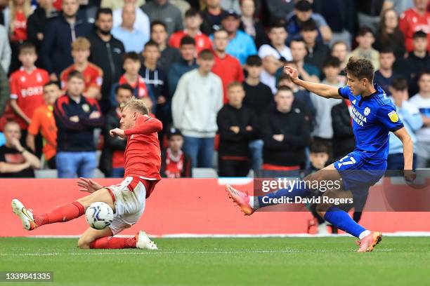 Rubin Colwill of Cardiff City scores his sides second goal despite the challenge from Joe Worrall of Nottingham Forest during the Sky Bet...