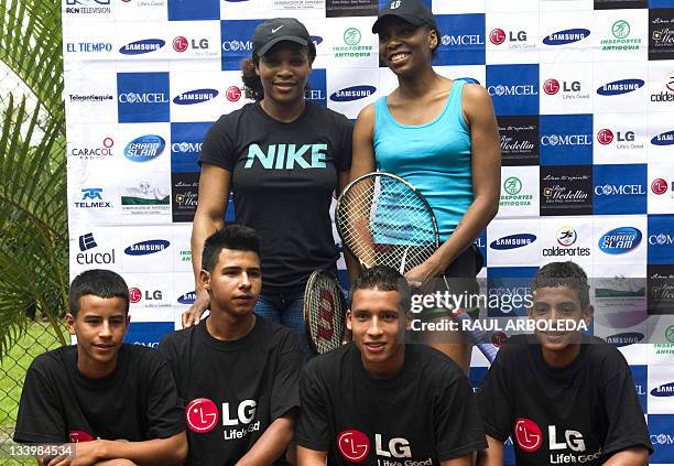 Tennis players Serena and Venus Williams pose with boys at the end of a training session in Medellin, Antioquia department, Colombia on November 23,...