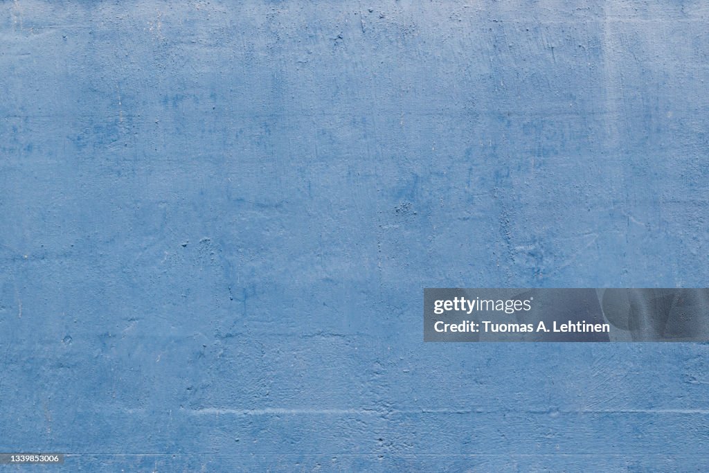 Close-up of plastered concrete wall painted in light blue.