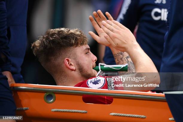 Harvey Elliott of Liverpool applauds the fans as he leaves the pitch on a stretcher following an injury during the Premier League match between Leeds...