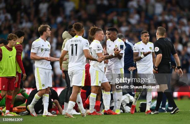 Junior Firpo of Leeds United is consoled by Kalvin Phillips as he looks dejected as Harvey Elliott of Liverpool receives medical treatment during the...
