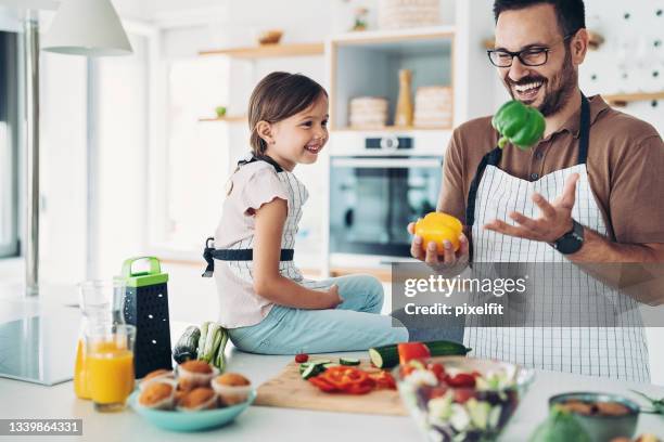 father juggling with peppers for his daughter - juggling stock pictures, royalty-free photos & images