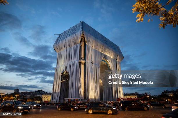 Workers begin the process of wrapping up the Arc De Triomphe monument in silver-blue fabric on September 12 in Paris, France. The monumental...