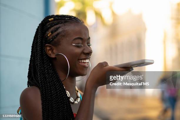 young woman sending voice message by smartphone - translation stock pictures, royalty-free photos & images