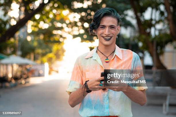 portrait of a gay man using smartphone - international day one stock pictures, royalty-free photos & images