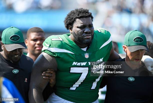 Mekhi Becton of the New York Jets is helped off the field after being injured during the third quarter against the Carolina Panthers at Bank of...