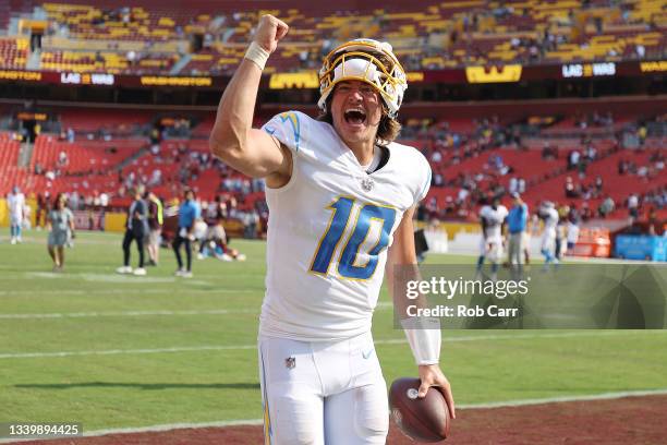 Justin Herbert of the Los Angeles Chargers celebrates after defeating the Washington Football Team 20-16 at FedExField on September 12, 2021 in...