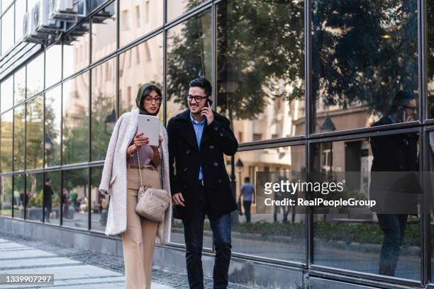 business couple is walking in the city streets. - man lady phone ipad outside stock pictures, royalty-free photos & images
