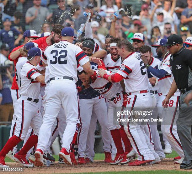 Leury Garcia of the Chicago White Sox is mobbed by teammates as he comes to the plate after hitting a walk-off, solo home run in the 9th inning...