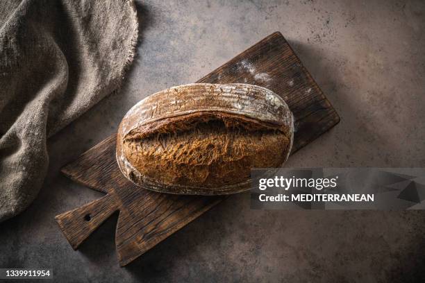 sourdough bread brown loaf homemade german style on cutting board - dark bread stock pictures, royalty-free photos & images