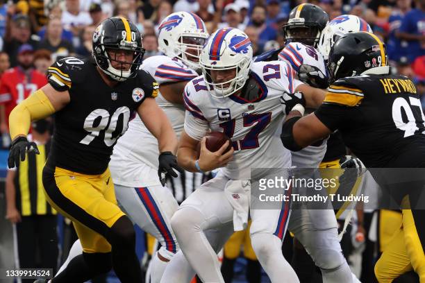 Josh Allen of the Buffalo Bills is pursued by Cameron Heyward and T.J. Watt of the Pittsburgh Steelers at Highmark Stadium on September 12, 2021 in...