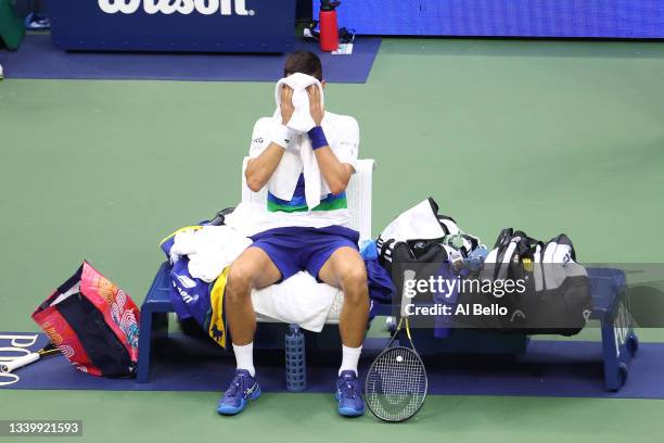 Novak Djokovic of Serbia covers his face during a changeover in the third set as he plays against Daniil Medvedev of Russia in the third set of the...