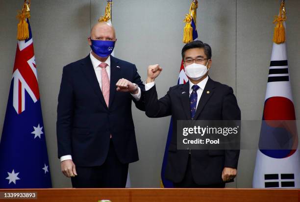 Australian Defense Minister Peter Dutton bumps elbows with South Korean Defense Minister Suh Wook prior their meeting a​t the Ministry of National...