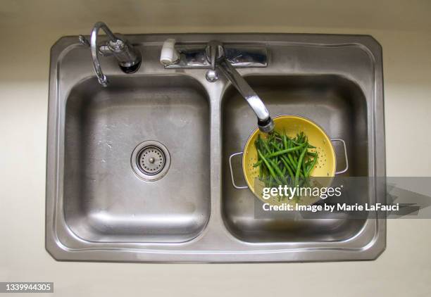 kitchen sink with green beans inside colander - kitchen sink stock pictures, royalty-free photos & images