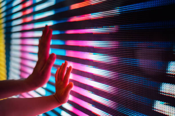 close up of a mother and kid's hand touching illuminated and multi-coloured led display screen, connecting to the future - comunicacion familia escuela fotografías e imágenes de stock