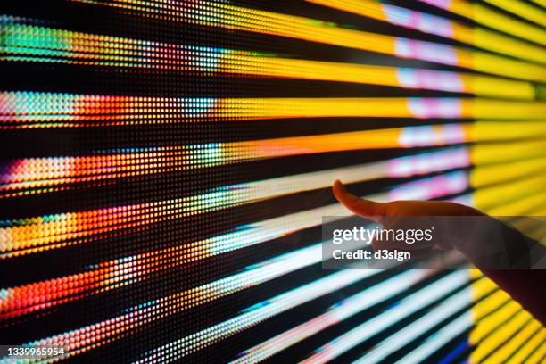 close up of a kid's hand touching illuminated and multi-coloured led display screen, connecting to the future - pantalla plasma fotografías e imágenes de stock
