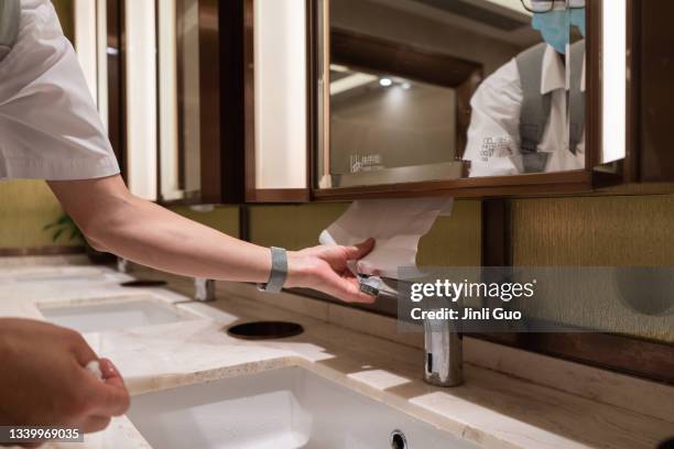 after washing your hands, take out the toilet paper from under the mirror - towel dispenser stock pictures, royalty-free photos & images