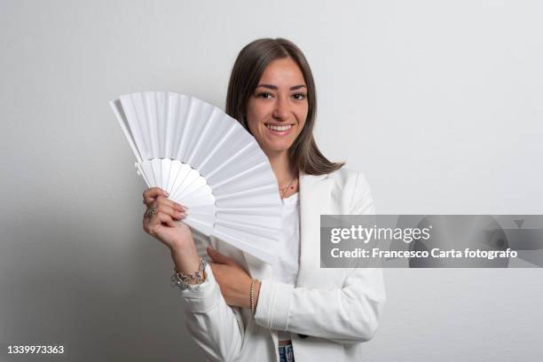 young woman holding folding fan - fächer stock-fotos und bilder