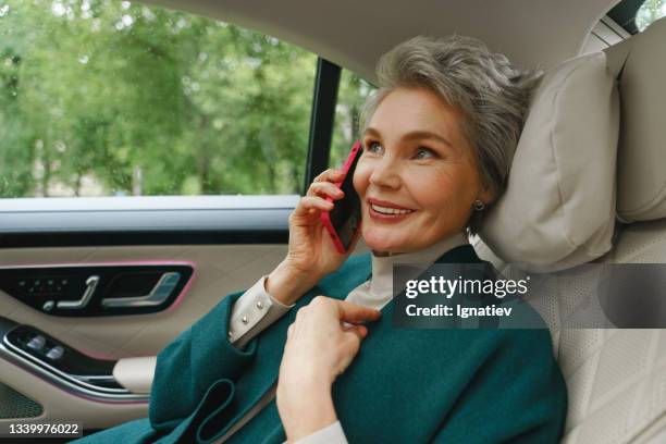 eine schöne geschäftsfrau telefoniert fröhlich auf dem weg ins büro - cosmetic sales woman stock-fotos und bilder