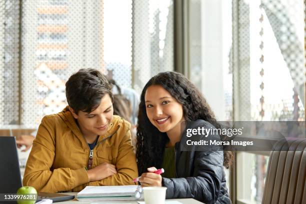 smiling students studying together in cafeteria - 19 to 22 years and friends and talking stock pictures, royalty-free photos & images