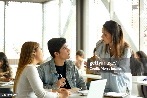 mature teacher teaching students in classroom - teacher and student stock pictures, royalty-free photos & images