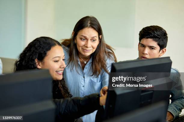 professor discussing with students in computer lab - estudiantes universitarios bogota fotografías e imágenes de stock