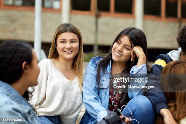 smiling friends talking in university campus - estudiantes universitarios bogota fotografías e imágenes de stock