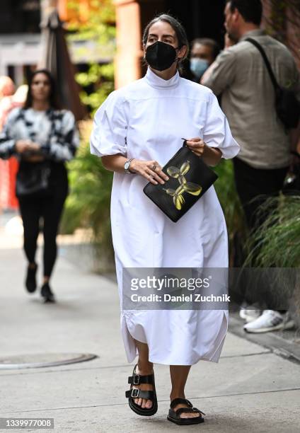 Guest is seen wearing a white shirt-dress outside the Tory Burch show during New York Fashion Week S/S 22 on September 12, 2021 in New York City.