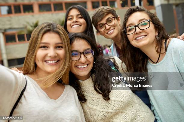 portrait of smiling friends in university campus - colombiaanse etniciteit stockfoto's en -beelden