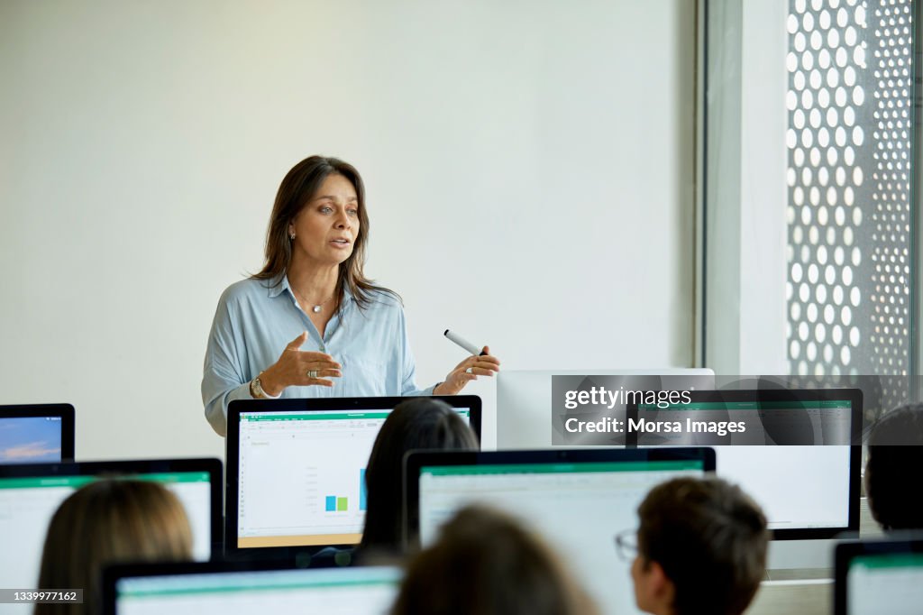 Female professor teaching students in computer lab